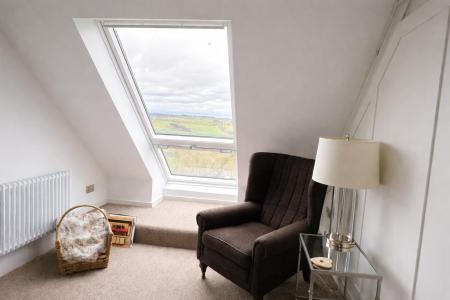 Cozy attic reading nook with skylight.png